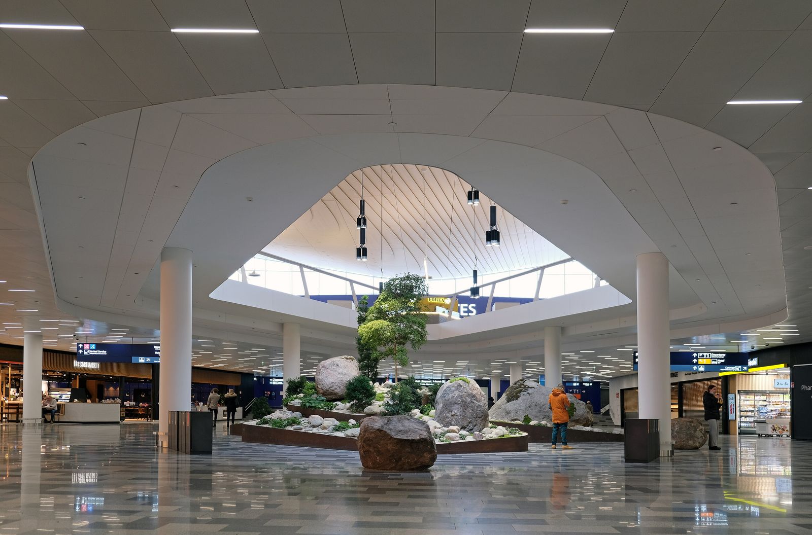 The bright, open departures hall of a modern airport terminal